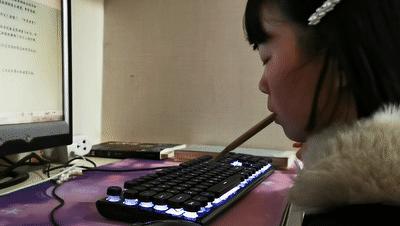 残疾女孩用嘴叼木棍写字,残疾女孩嘴叼木棍