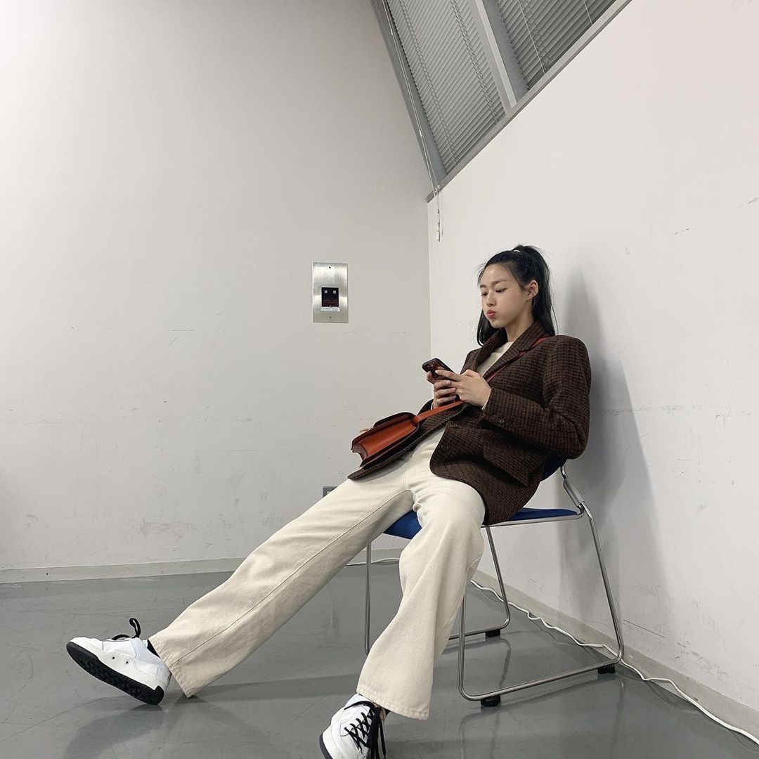 她是zico的前女友，深蓝风衣内搭灰卫衣出镜，身材依旧没的说